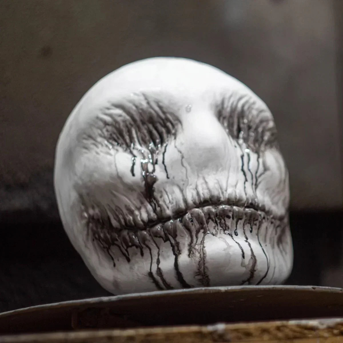 White sculpted mask with black drip details, textured finish, bold streetwear accessory