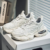 Chunky white mesh and leather sneakers with thick soles, modern streetwear style, lace-up fit.