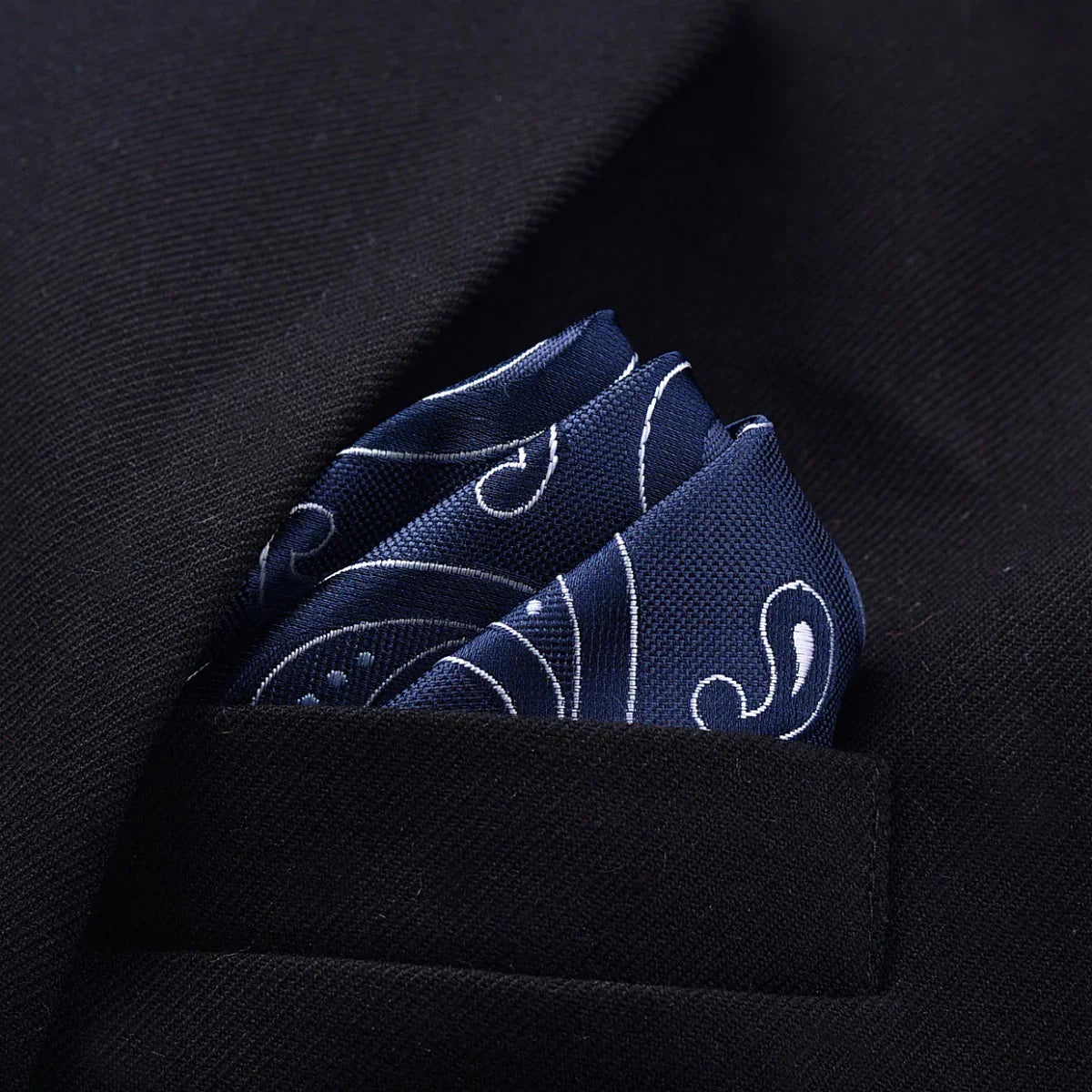 Navy blue paisley silk pocket square in black blazer pocket, modern formal style