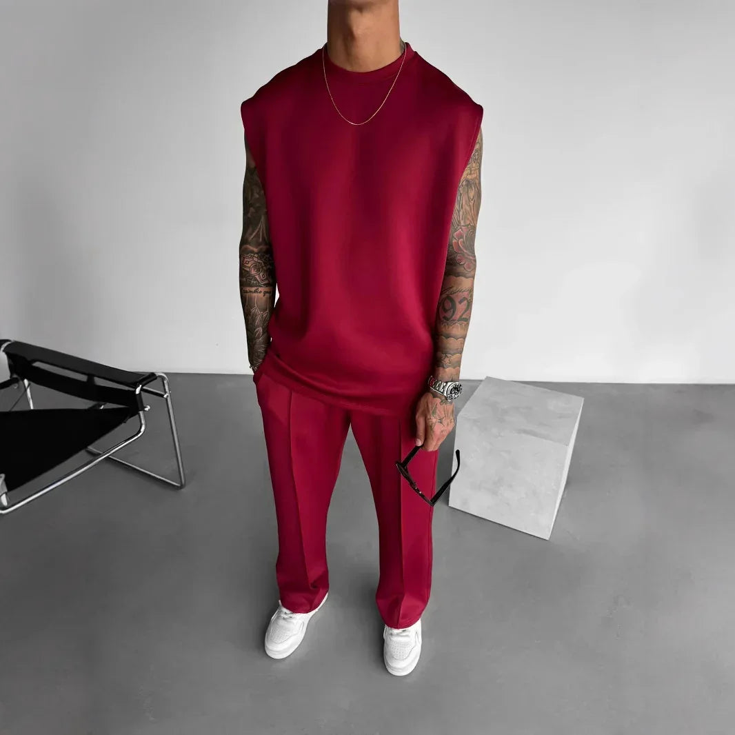 Man wearing loose-fit sleeveless burgundy top and matching trousers, minimalist style
