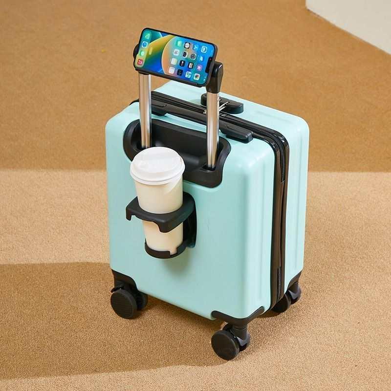 Light blue hard-shell suitcase with cup holder, phone holder, and spinner wheels on carpet floor.