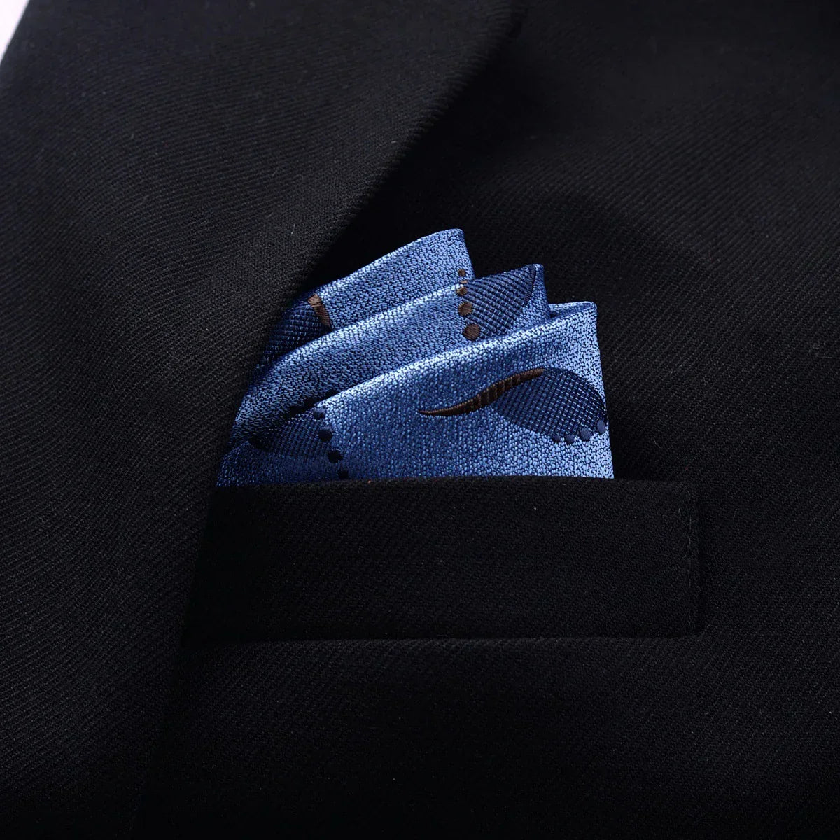 Blue patterned silk pocket square in black suit jacket pocket, formal menswear accessory