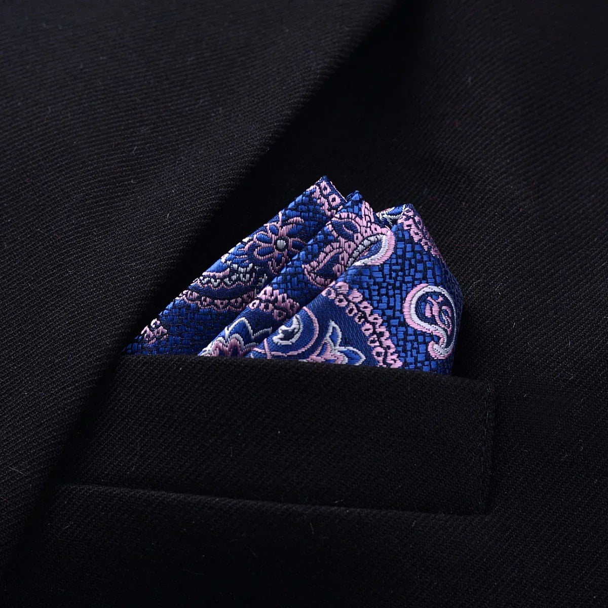 Blue paisley silk pocket square in black suit jacket chest pocket, modern formal style