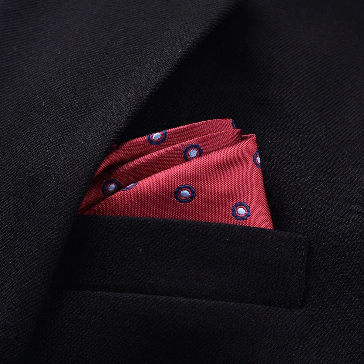 Red patterned silk pocket square in black suit jacket pocket, elegant streetwear accessory