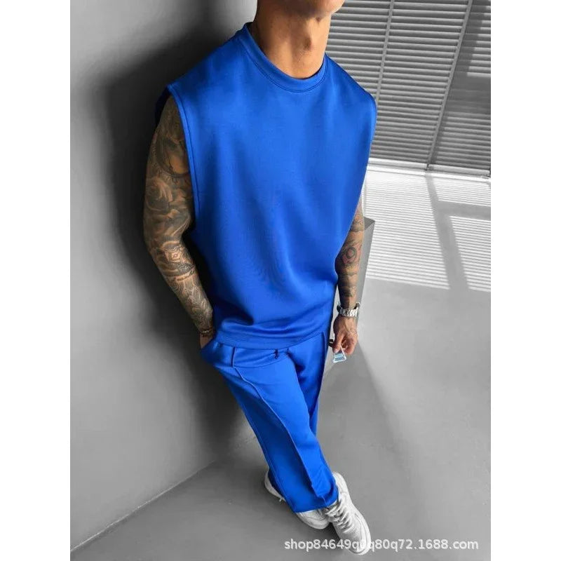 Man wearing a blue sleeveless oversized top and matching jogger pants set in modern streetwear style