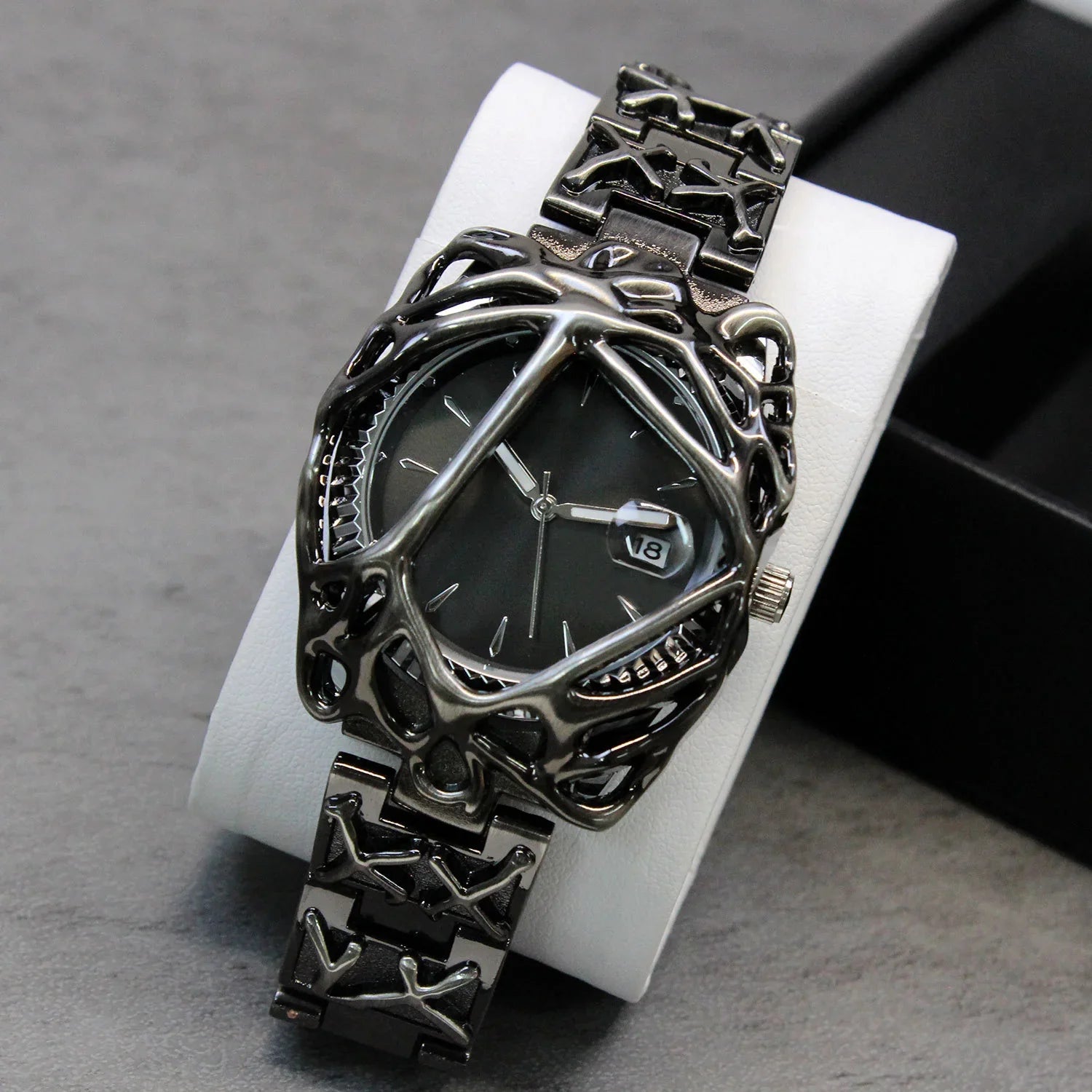Futuristic metallic watch with intricate black skeleton-style case and bracelet, minimalist dial