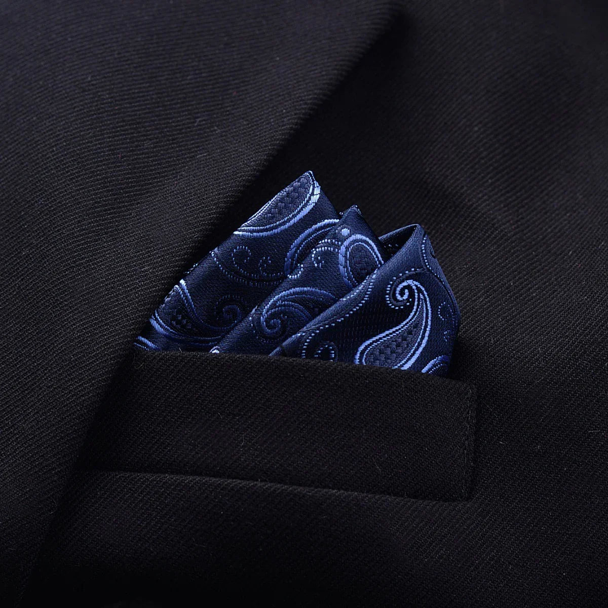 Black suit with navy blue paisley silk pocket square, classic tailored formalwear