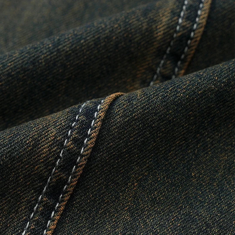 Close-up of dark blue denim fabric with visible stitching, highlighting texture and sturdy material.