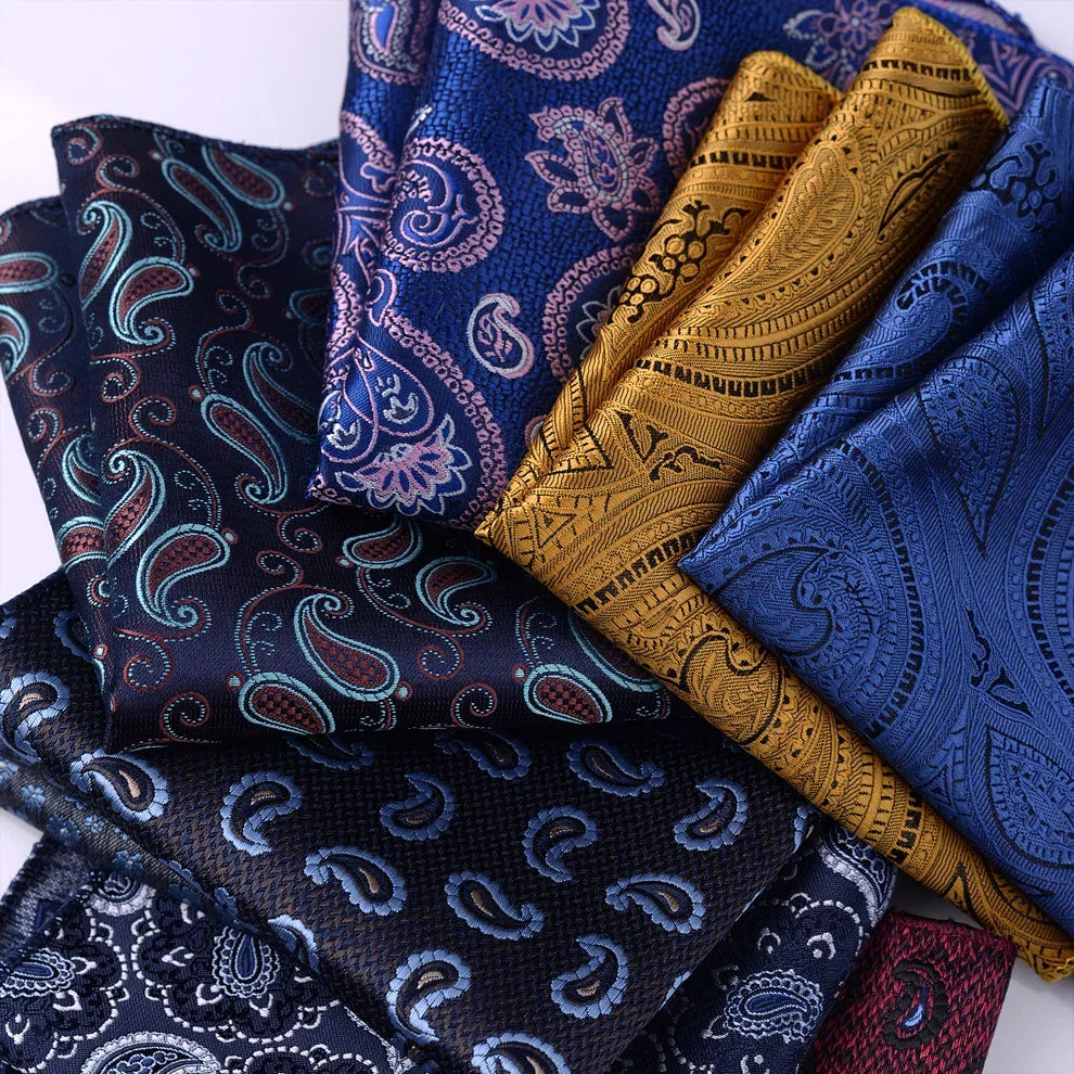 Assorted silk pocket squares with paisley and floral patterns in blue, gold, and black tones