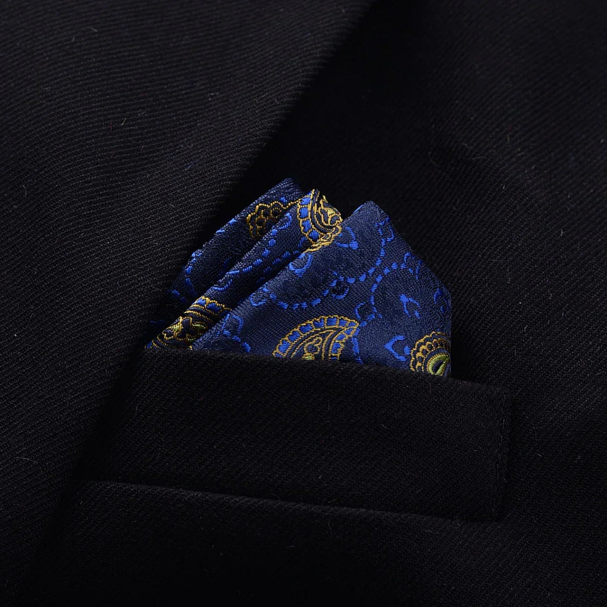 Navy blue paisley silk pocket square in black suit jacket breast pocket, elegant style