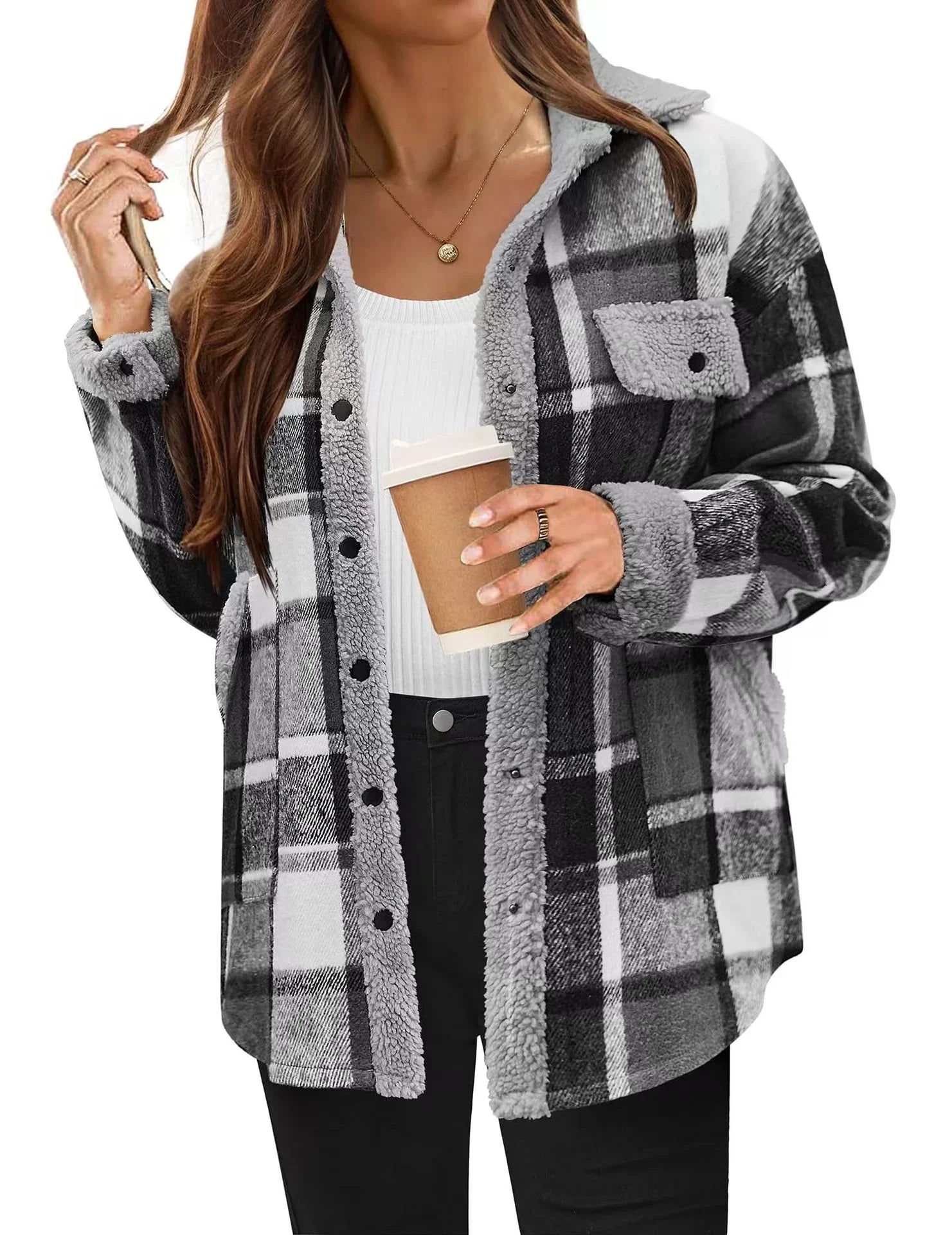 Woman wearing black and white plaid sherpa jacket, white ribbed top, and black pants
