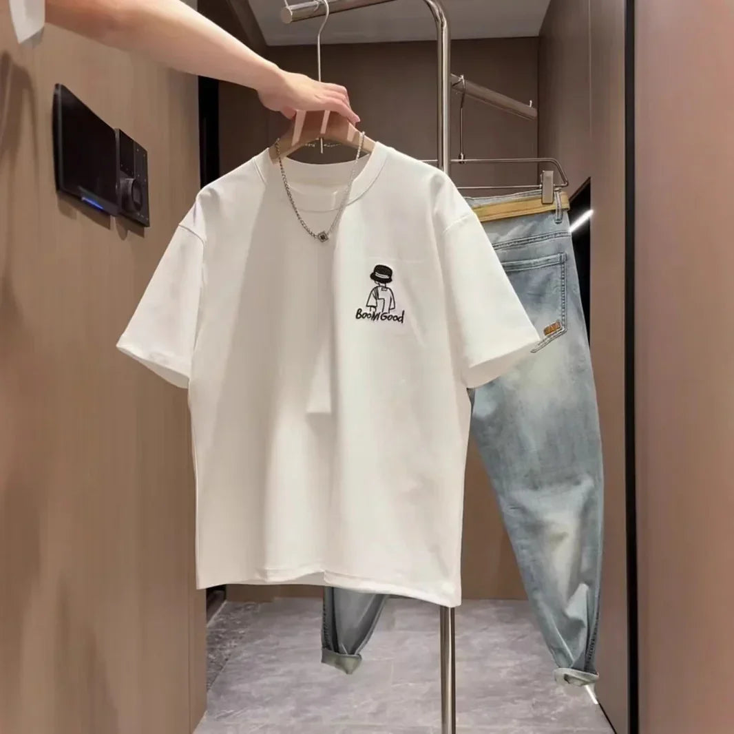 White graphic oversized t-shirt with embroidery, paired with light wash relaxed fit jeans.