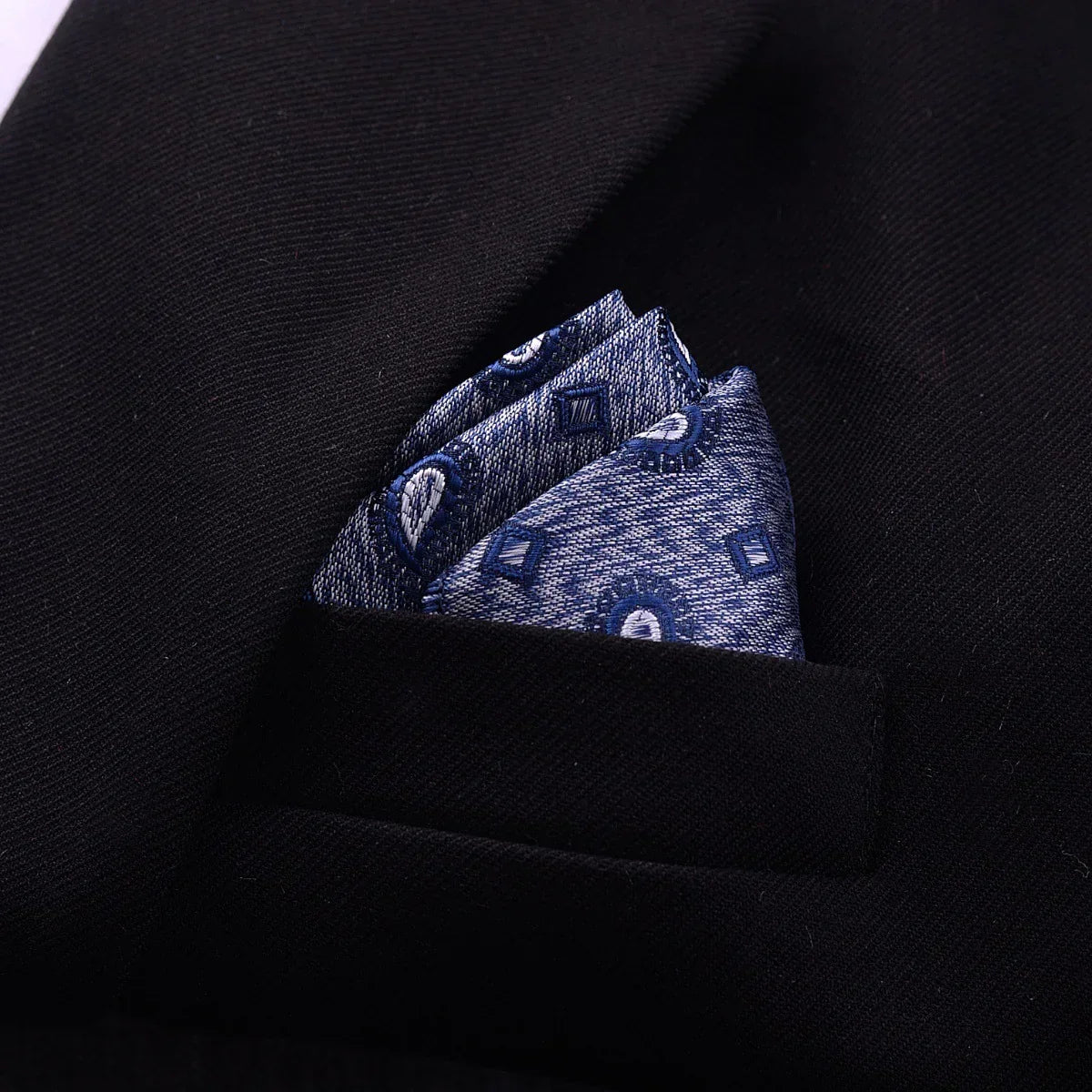 Blue patterned pocket square in a black suit jacket, modern streetwear accessory