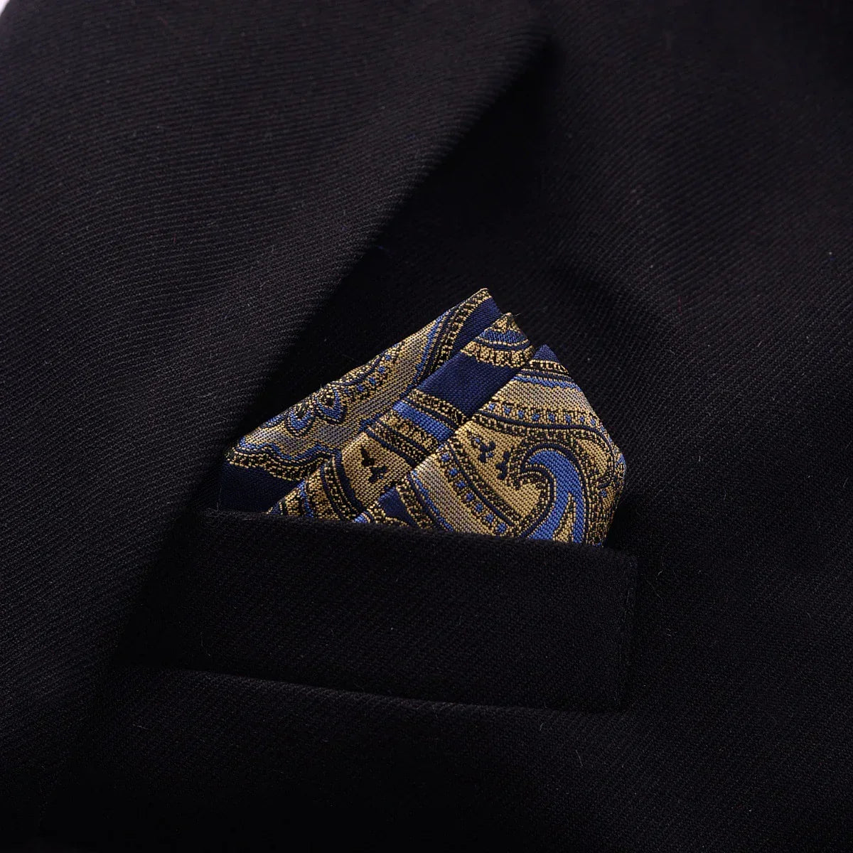 Black blazer with gold and navy paisley silk pocket square, close-up view