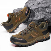 Brown suede low-top hiking shoes with black accents, rugged soles, and lace-up design