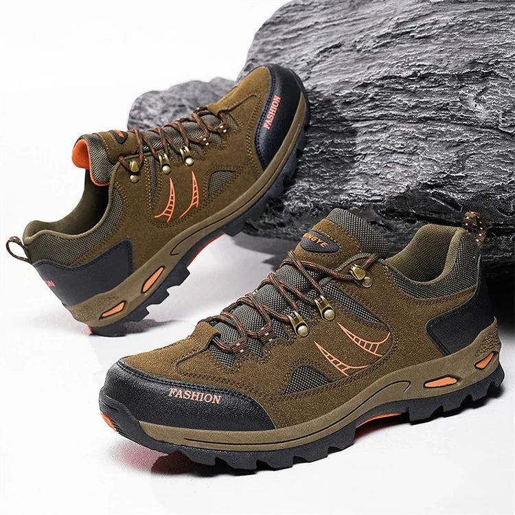 Brown suede low-top hiking shoes with black accents, rugged soles, and lace-up design