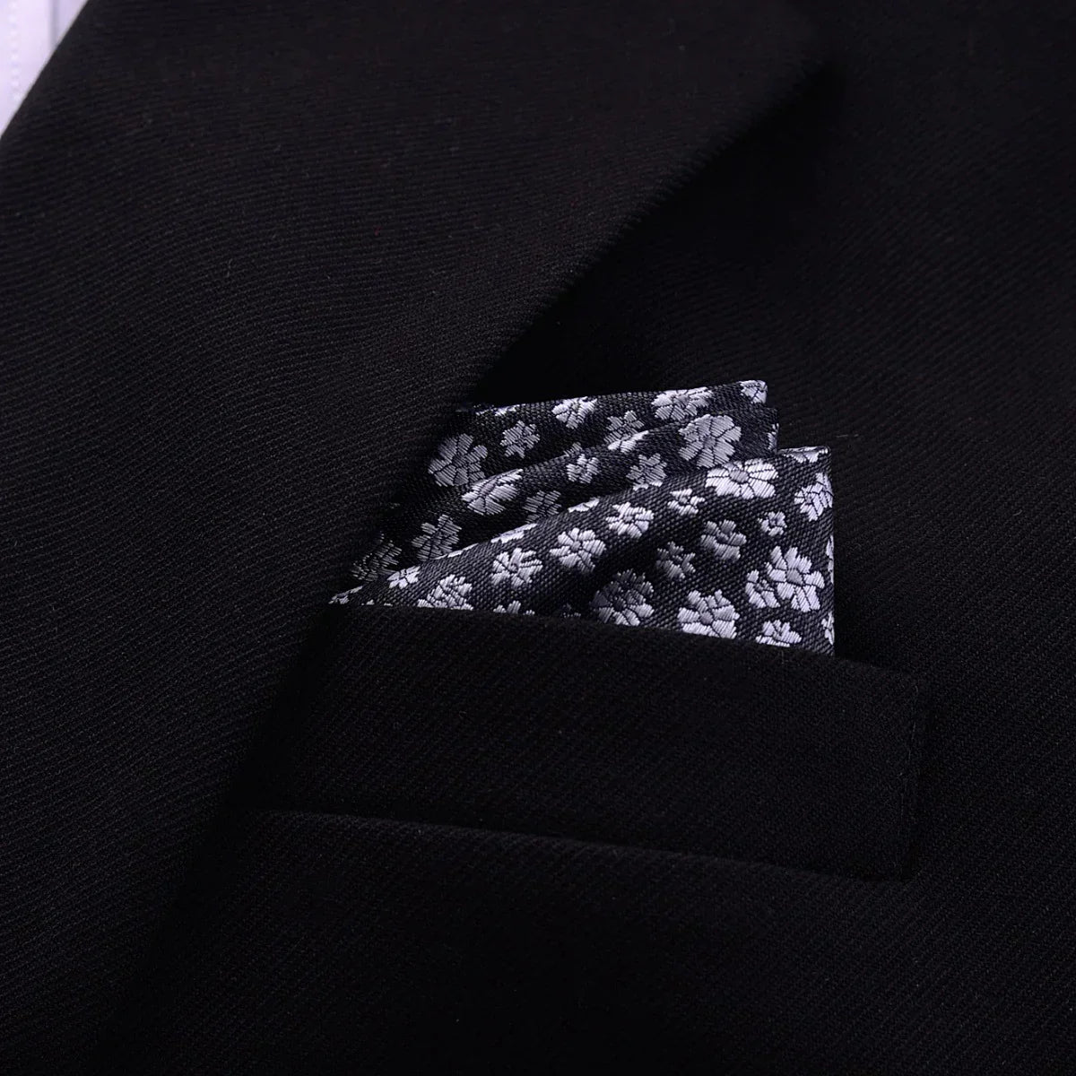 Black suit jacket with a floral patterned pocket square, tailored modern fit