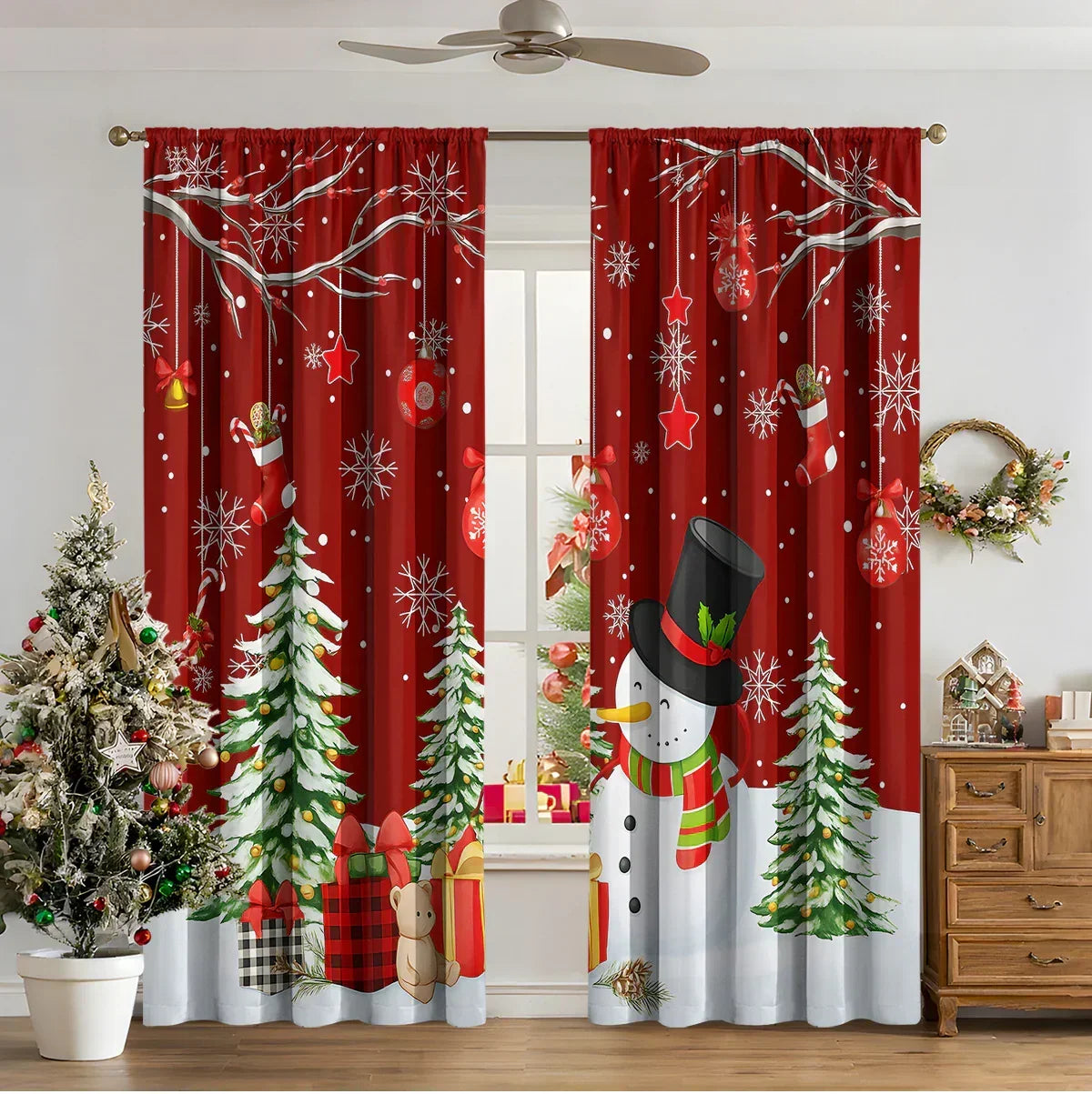 Red Christmas-themed curtains with snowman, pine trees, snowflakes, and holiday gifts in a festive living room setting.