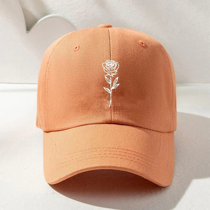 Peach orange cotton baseball cap with white embroidered rose graphic, casual streetwear style