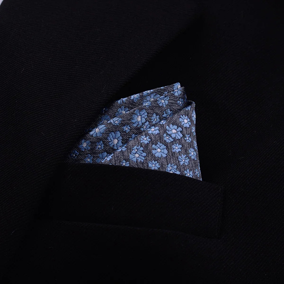 Blue floral pocket square in black suit jacket, modern streetwear accessory