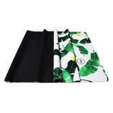 Folded travel mat with green leaf print, rubber backing, lightweight and portable design