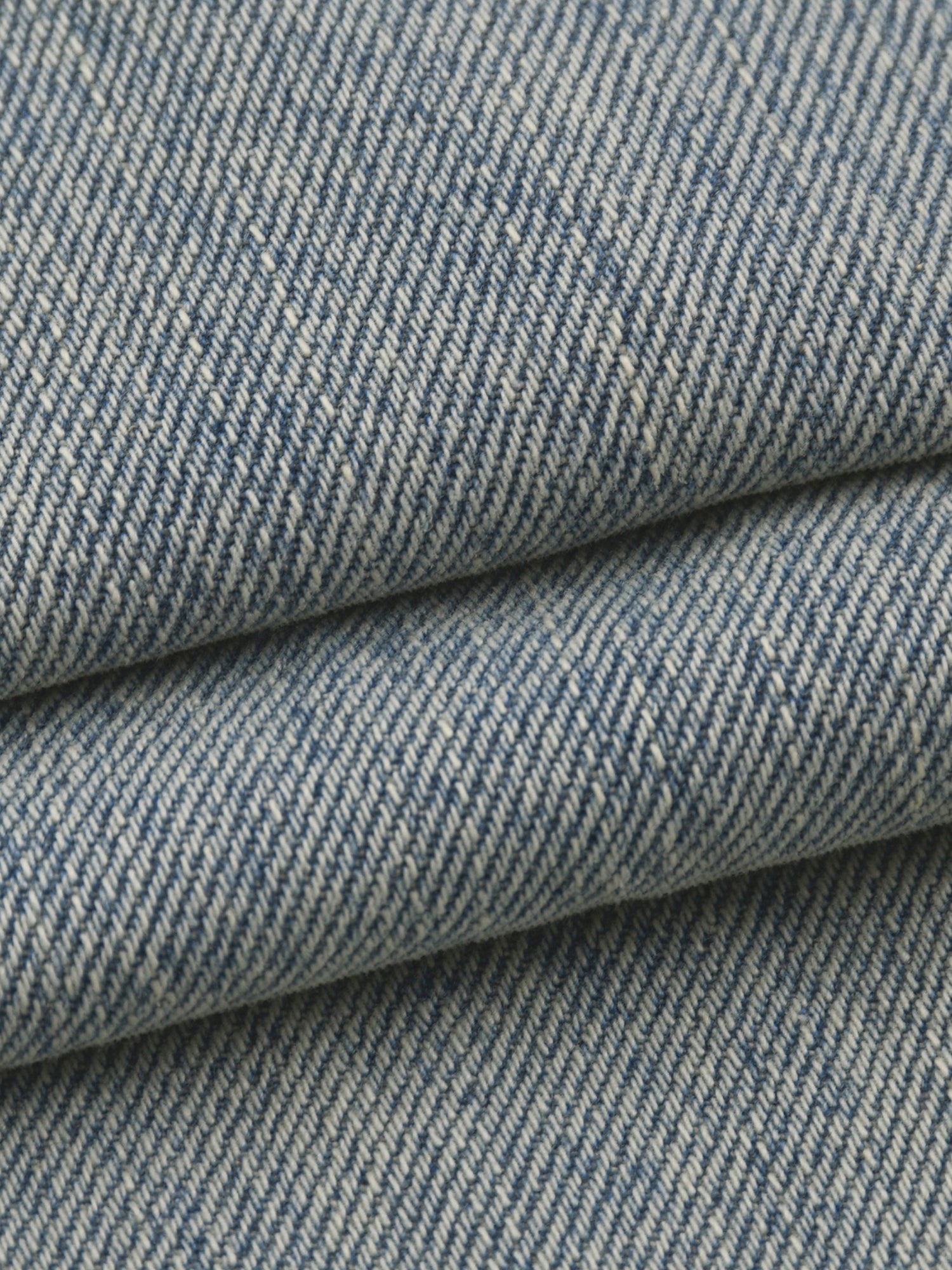 Close-up of blue denim fabric with a subtle pattern