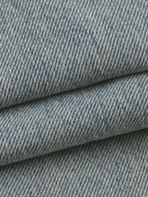 Close-up of blue denim fabric with a subtle pattern
