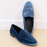 Blue velvet loafers with a slip-on design, low heel, and sleek modern fit