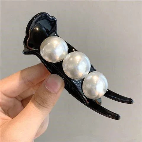 Black plastic hair clip with three large faux pearl accents, glossy finish, elegant style