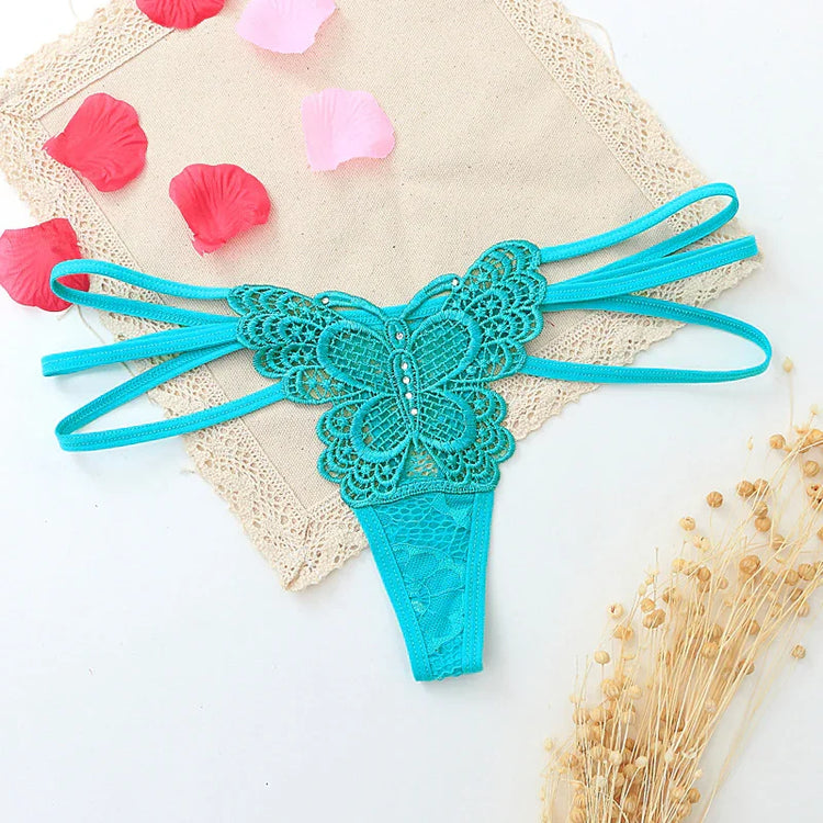 Turquoise lace butterfly thong with strappy sides and floral embroidery, laid flat.