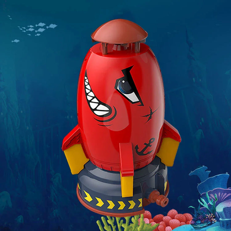 Red plastic submarine toy with cartoon face, yellow fins, and anchor design, underwater setting