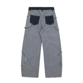 Wide-leg grey denim jeans with raw-edge dark pockets and distressed seam details