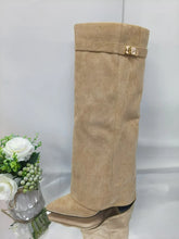 Beige suede knee-high boot with pointed toe, slouchy fit, and gold buckle detail