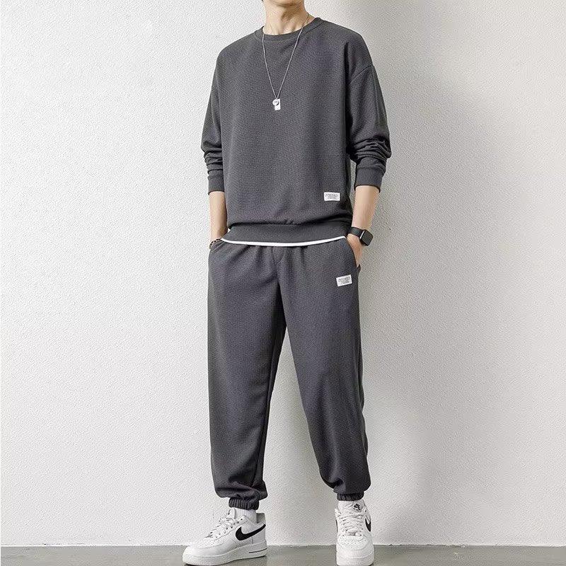 Man in relaxed-fit dark gray sweatshirt and joggers set, casual streetwear style