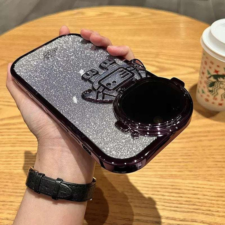 Hand holding a silver glitter astronaut phone case with 3D detailing and glossy finish