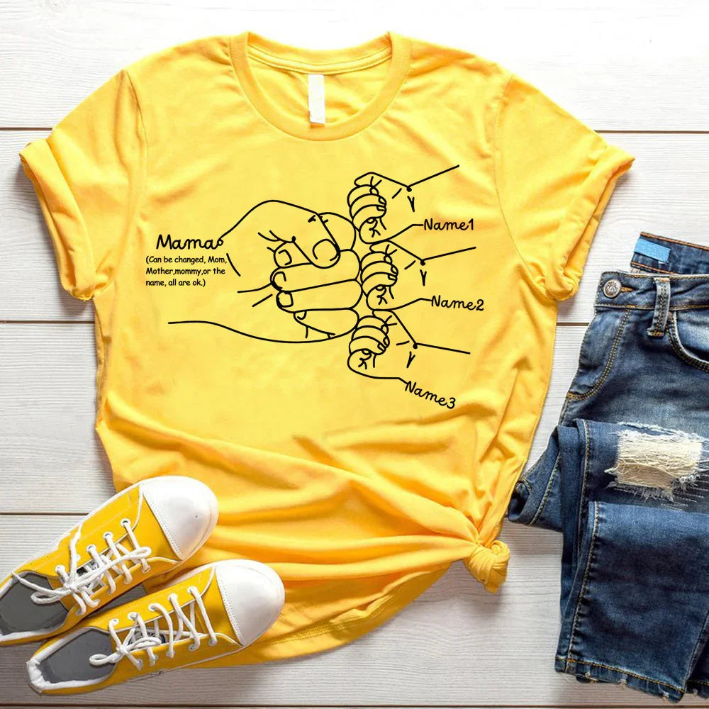 Yellow graphic t-shirt with hand-drawn family hands design, shown with denim shorts and sneakers.