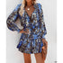 Woman wearing a blue and black abstract print mini dress with long sleeves and relaxed fit