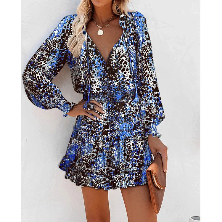 Woman wearing a blue and black abstract print mini dress with long sleeves and relaxed fit