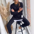 Woman wearing black oversized sweatshirt and joggers, white sneakers, relaxed fit streetwear