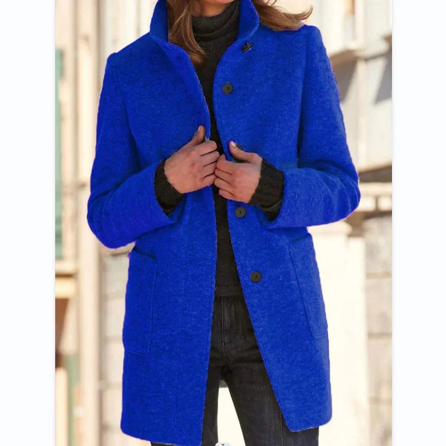 Woman wearing a vibrant blue wool coat with button closure, fitted style, and side pockets