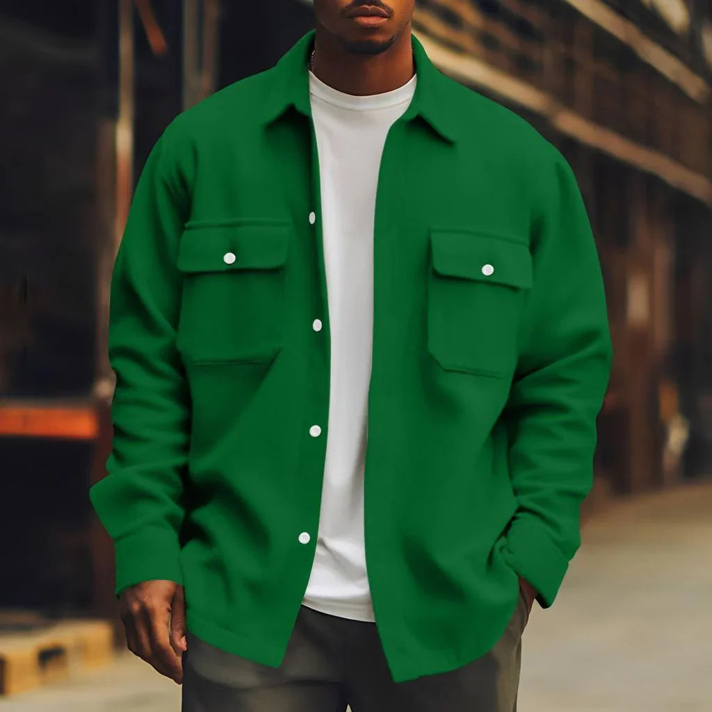 Man wearing a loose fit green button-up shirt jacket with flap pockets over a white t-shirt