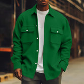 Man wearing a loose fit green button-up shirt jacket with flap pockets over a white t-shirt
