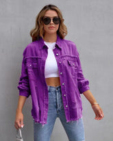 Woman in oversized purple distressed denim jacket, cropped white top, and high-waisted jeans