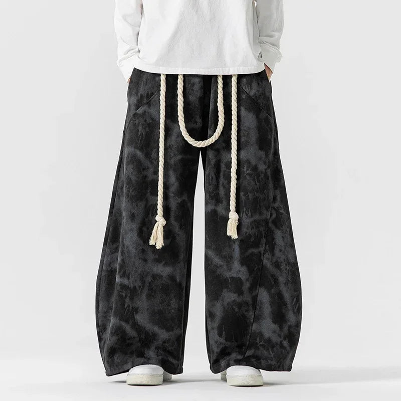 Black tie-dye wide-leg pants with rope belt, loose fit streetwear style.