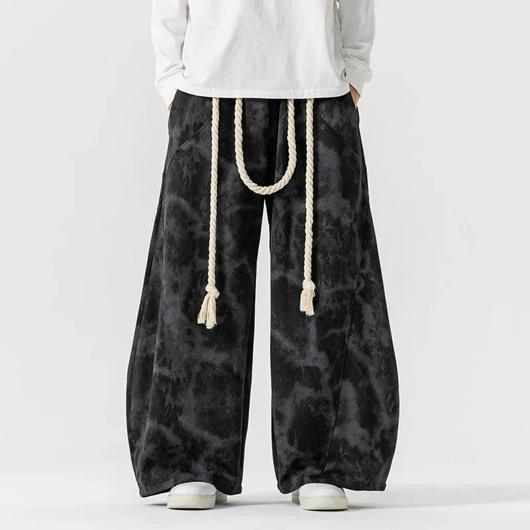Black tie-dye wide-leg pants with rope belt, loose fit streetwear style.