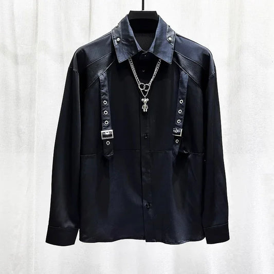 Black long sleeve shirt with metal buckle straps, grommet details, and silver chain necklace, modern streetwear style.