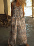 Woman wearing loose fit sleeveless floral print jumpsuit with wide legs and front buttons