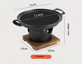 Compact black cast iron tabletop grill oven with wooden base, dimensions labeled in centimeters.