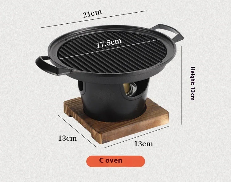 Compact black cast iron tabletop grill oven with wooden base, dimensions labeled in centimeters.