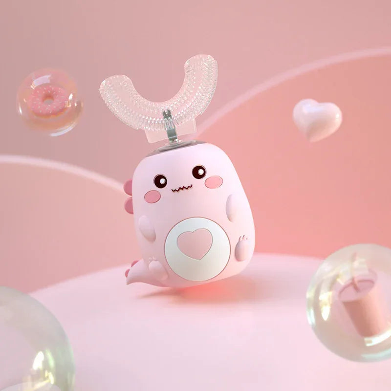 Cute pink silicone automatic toothbrush with cartoon face, heart detail, and U-shaped mouthpiece.